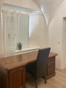 a desk with a chair in front of a window at Apartment Bessi in Olomouc