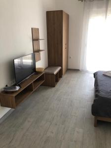 a living room with a flat screen tv and a couch at Adla Apartmani in Ulcinj