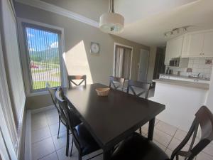 a kitchen and dining room with a table and chairs at Condos Vacances MSA AVEC PARC AQUATIQUE GRATUIT! in Beaupré