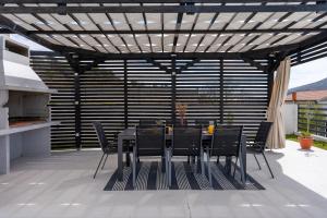 einen Tisch und Stühle unter einer Pergola auf einer Terrasse in der Unterkunft Villa Mirage in Tugare
