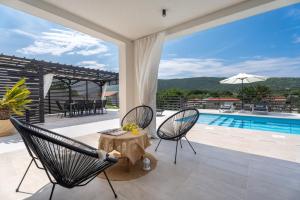 eine Terrasse mit Tisch und Stühlen und ein Swimmingpool in der Unterkunft Villa Mirage in Tugare