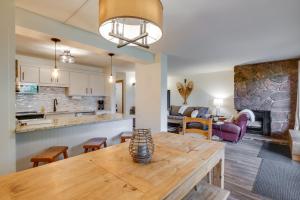 a kitchen and living room with a wooden table at Walk to Ski Shuttle: Cozy Mountain Meadows Condo in Frisco