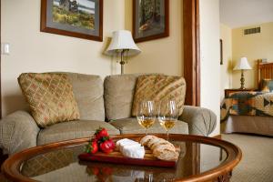 Chestnut Inn at Oquaga Lake في Deposit: غرفة معيشة مع أريكة وطاولة مع كؤوس للنبيذ