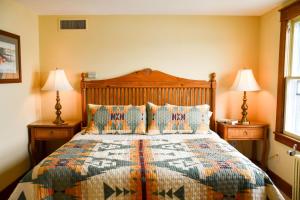 Chestnut Inn at Oquaga Lake في Deposit: غرفة نوم بسرير كبير فيها مصباحين