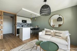 uma sala de estar com um sofá branco e um espelho em Magnifique Studio - Beach Side Bliss em La Grande-Motte
