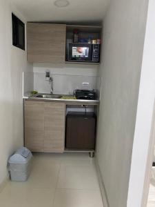 uma pequena cozinha com um lavatório e um micro-ondas em Apartamento en Envigado em Envigado