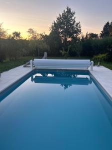 a swimming pool with a sunset in the background at Chambre d’hôtes avec piscine in Éguzon-Chantôme