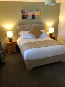 una camera con un grande letto con due lampade di Harbour View Bed & Breakfast a Castletownbere
