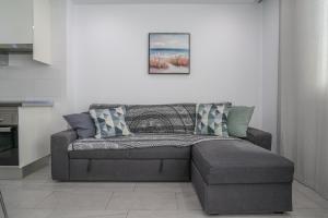 a living room with a couch with pillows on it at GO2TENERIFE Apart'Teno Amazing pool view & near the beach in Playa de las Americas