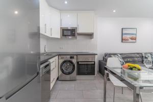 a kitchen with a sink and a dishwasher at GO2TENERIFE Apart'Teno Amazing pool view & near the beach in Playa de las Americas +15 photos