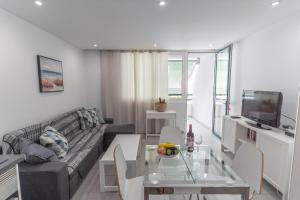 a living room with a couch and a table at GO2TENERIFE Apart'Teno Amazing pool view & near the beach in Playa de las Americas
