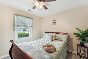 um quarto com uma cama, uma ventoinha de tecto e uma janela em Quaint Jacksonville Getaway Near Camp Lejeune! em Jacksonville