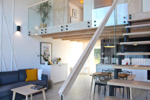 a living room with a blue couch and a staircase at Sea2 in Nowęcin