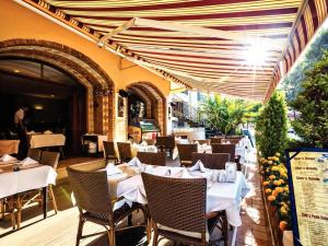 un restaurante con mesas y sillas blancas y una persona en Club Anastasia - Family Hotel, en Marmaris