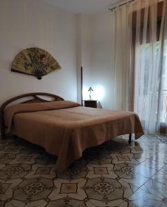 a bedroom with a bed and a large window at Casa Vacanza Di Maggio in Cinisi