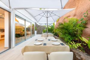a dining room with a table and chairs and an umbrella at Grand Horizon Luxury Boutique Apartments in Puerto Rico de Gran Canaria