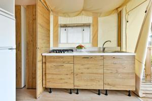 a kitchen with a sink and a stove at Polidor Glamping Resort in Poreč