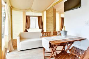 a living room with a table and a couch at Polidor Glamping Resort in Poreč +21 photos