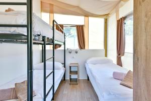 a room with two bunk beds and a window at Polidor Glamping Resort in Poreč