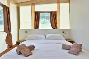 a bedroom with a bed with two towels on it at Polidor Glamping Resort in Poreč