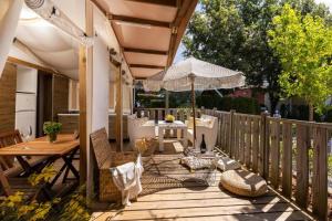 a wooden deck with a table and an umbrella at Polidor Glamping Resort in Poreč