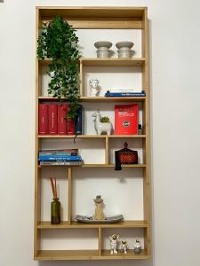 een houten boekenplank met items erop bij Naudas House! in Pero