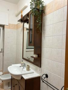 ein Bad mit einem Waschbecken und einem Spiegel in der Unterkunft Naudas House! in Pero