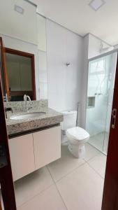 a bathroom with a toilet and a sink and a shower at Mundial Flat in Viçosa