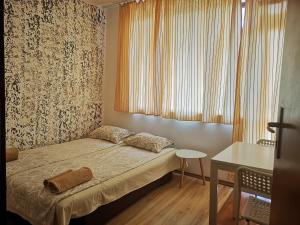 Dormitorio pequeño con cama y mesa en Paunovi Guest House en Primorsko