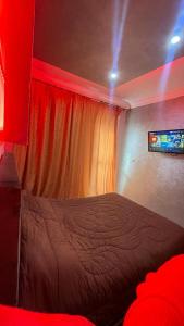 1 dormitorio con 1 cama en una habitación con luces rojas en holiday and beach self check-in en Agadir