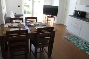 a dining room with a table with chairs and a television at Snorky apartments in Azzano San Paolo