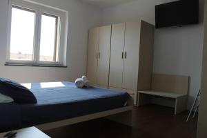 a bedroom with a bed and a cabinet and a window at Snorky apartments in Azzano San Paolo