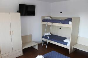 a room with a bunk bed with a tv and a ladder at Snorky apartments in Azzano San Paolo
