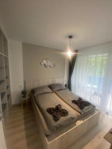 ein Schlafzimmer mit einem Bett mit zwei braunen Objekten darauf in der Unterkunft Lake View Apartman in Hajdúszoboszló