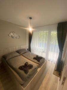 ein Schlafzimmer mit einem Bett mit zwei Kreuzen darauf in der Unterkunft Lake View Apartman in Hajdúszoboszló