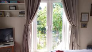 1 dormitorio con una gran ventana con cortinas en Littlebeck en Danby