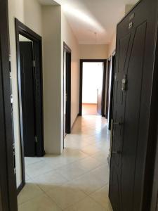un corridoio con porte nere e pavimento piastrellato di شقة في بورصة التركية 