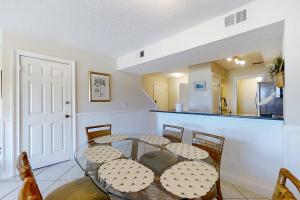 a dining room with a table and chairs and a kitchen at 207 Sailmaker in Fernandina Beach
