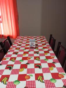 een tafel met een rode en witte tafeldoek met bananen erop bij Como en casa in Campo Grande