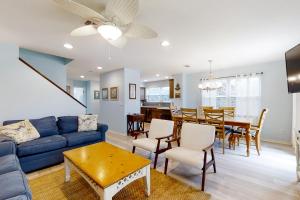 a living room with a blue couch and a dining room at 212 Sailmaker in Fernandina Beach