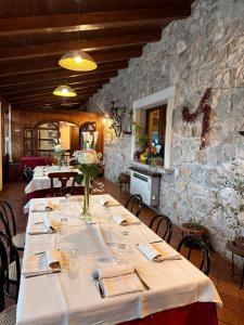 uma fila de mesas numa sala com uma parede de pedra em Agriturismo Il Pozzo em Polla