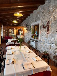 a row of tables in a room with a stone wall at Agriturismo Il Pozzo in Polla