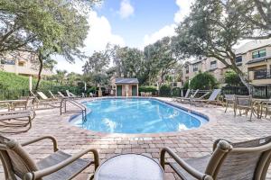 a swimming pool with lounge chairs and a table at 212 Sailmaker in Fernandina Beach