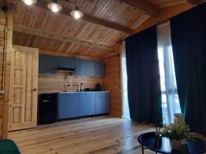 a kitchen with blue cabinets and a table in a room at Гостевой дом Фазенда in Pizunda