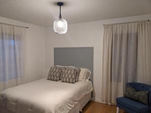 1 dormitorio con 1 cama y luz colgante en Mid Century Style Cottage Near Historic Downtown en Eustis