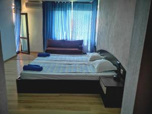 a large bed in a room with a window at Paunovi Guest House in Primorsko