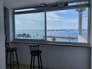 a window with two chairs and a view of the ocean at Libertad 109 Hotel in La Libertad