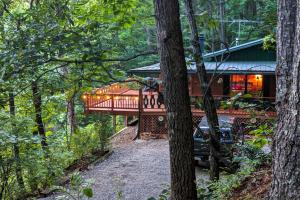 una casa en el bosque con una cubierta envolvente en Black Bear Cabin Fox Mountain, en Franklin