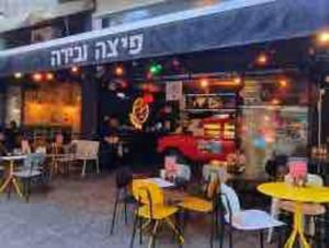 a restaurant with tables and chairs in front of it at luxury apartment & backyard in Tel Aviv