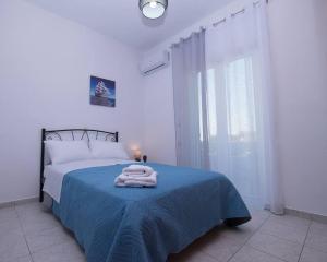 Un dormitorio blanco con una cama con toallas. en Kardiakos Stay, en Galatás